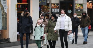People with and without protective masks against COVID-19 walk on a street in Istanbul, Turkey, Jan. 14, 2022. (DHA PHOTO)