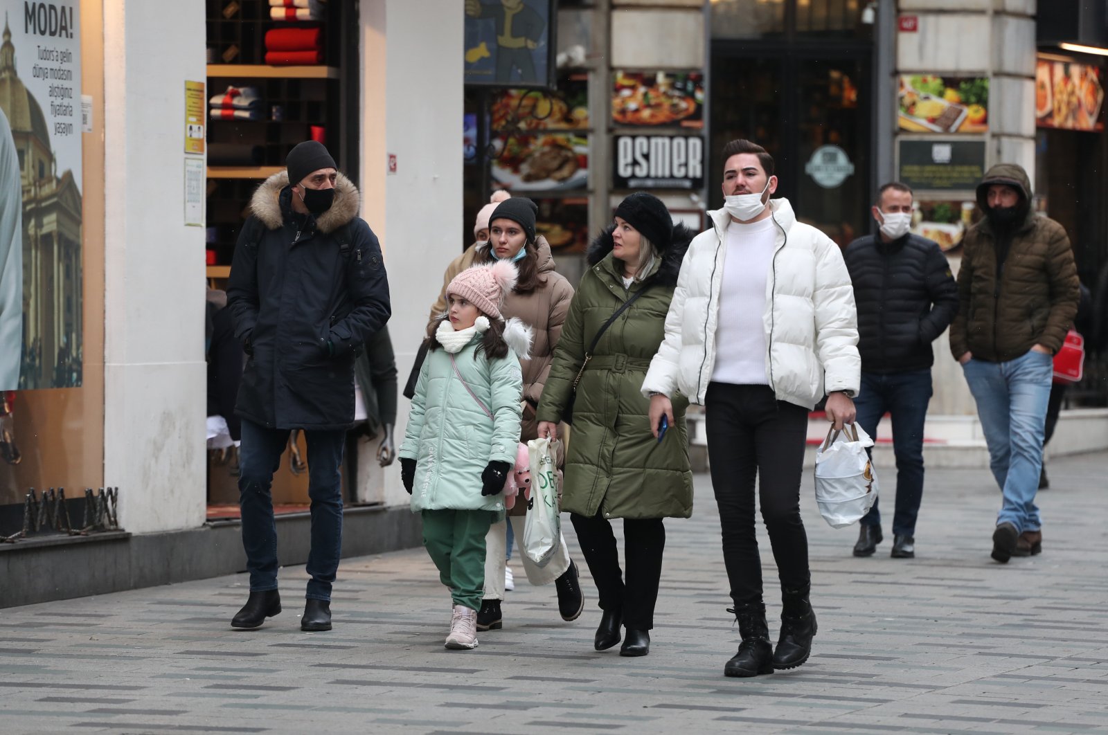 People with and without protective masks against COVID-19 walk on a street in Istanbul, Turkey, Jan. 14, 2022. (DHA PHOTO)