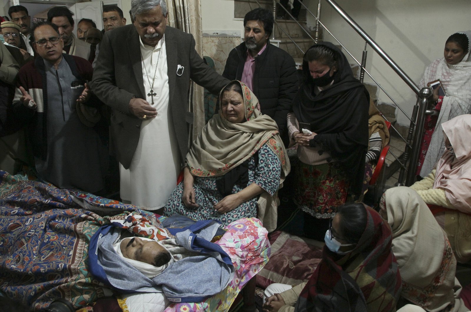 Relatives of Christian priest Father William Siraj, 75, who was killed by unknown gunmen, mourn next to his body at his home in Peshawar, Pakistan, Jan. 30, 2022. (AP Photo)