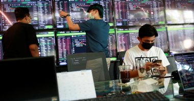 People pass their time at a cafe that has dozens of screens showing the latest trends and prices on various cryptocurrencies for their crypto investors' customers in Nakhon Ratchasima, Thailand, Jan. 21, 2022. (Reuters Photo)