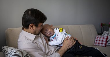 Veysel Çözvelioğlu embraces his father Mustafa Çözvelioğlu in their home, in the capital Ankara, Turkey, Jan. 31, 2022. (AA PHOTO)