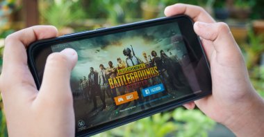 Hand holding a smartphone with Player&#039;s Unknown Battleground, also known as PUBG, online shooting game, Kuala Lumpur, Malaysia, Sep. 7, 2018. (Shutterstock)