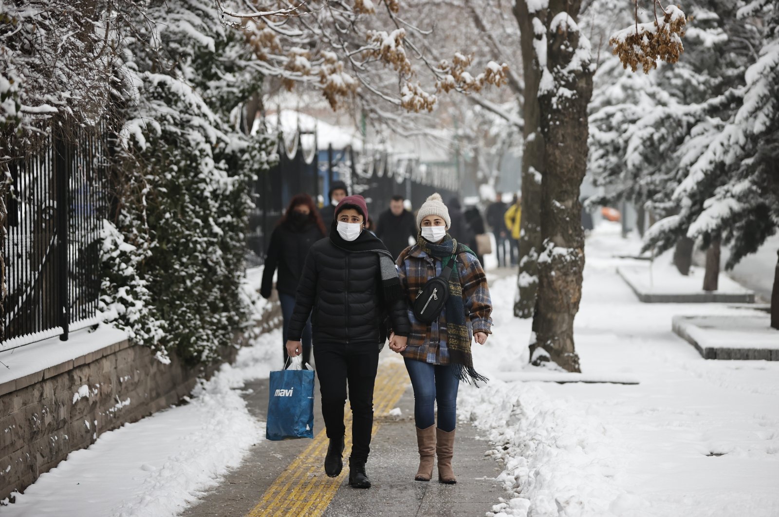 People wearing protective masks walk on a street, in the capital Ankara, Turkey, Jan. 31, 2022. (AA Photo)