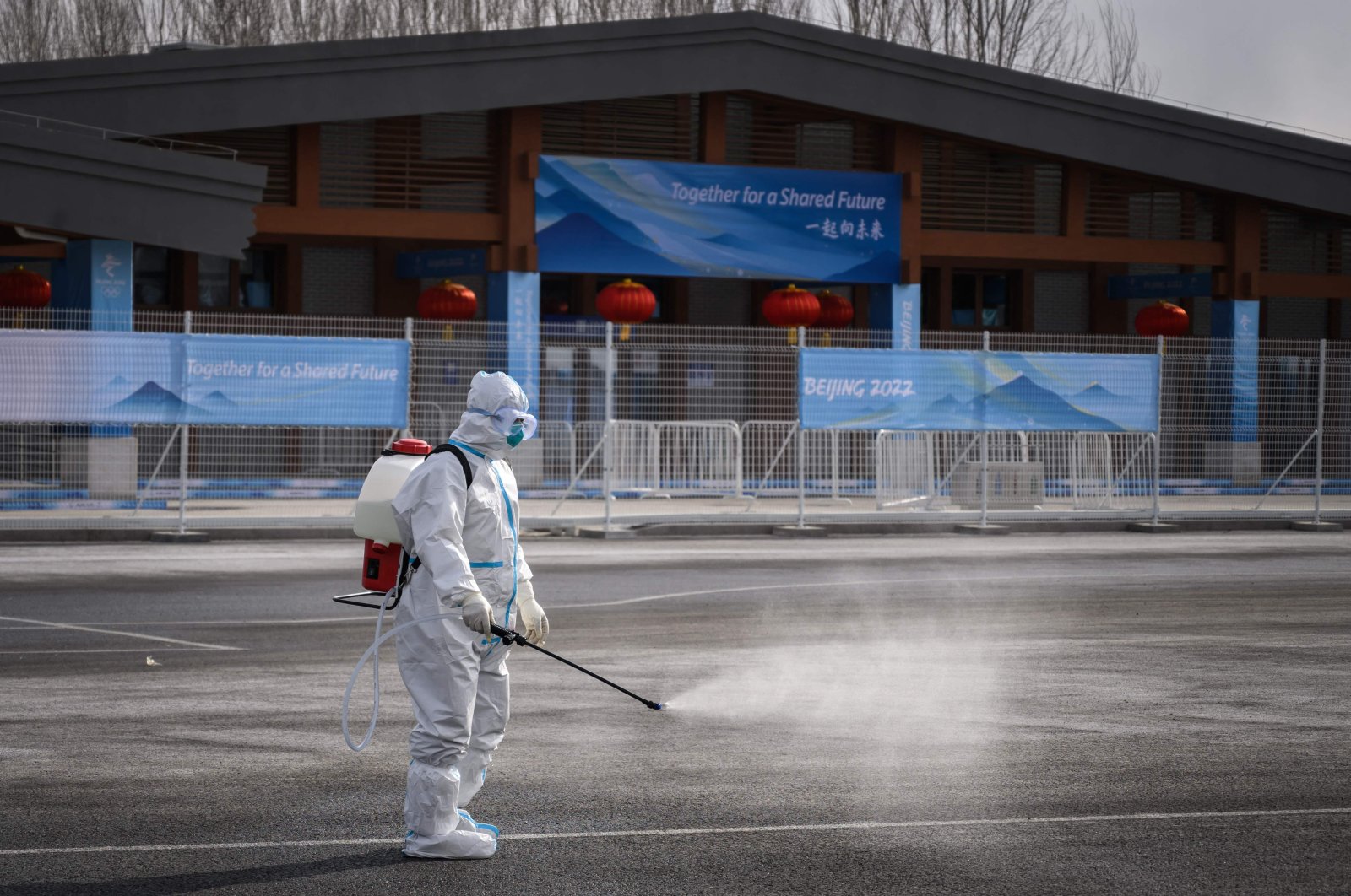 A man in hazmat suit sprays disinfectant against COVID-19 near a Winter Olympics venue, Beijing, China, Jan. 31, 2022. (AFP Photo)