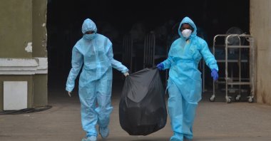  Indian health workers carry the medical waste for disposal at the Chennai Trade Centre (CTC) which is converted into a makeshift COVID-19 care facility for coronavirus patients, Chennai, India, Jan. 16, 2022. (EPA Photo) 