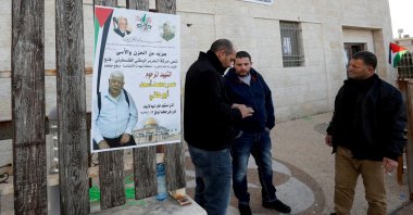 Men stand next to a poster of Palestinian Omar Abdalmajeed As'ad, in Jiljilya village in the Israeli-occupied West Bank, Jan. 12, 2022. (Reuters Photo)