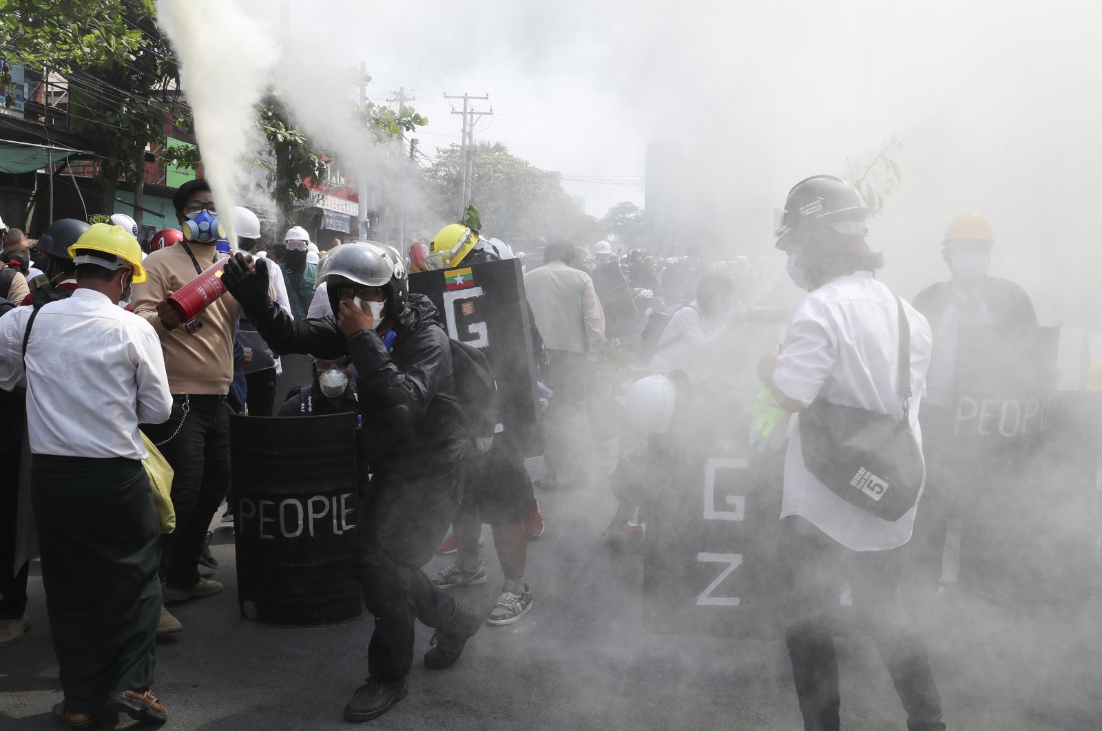 Anti-coup protesters discharge fire extinguishers to counter the impact of the tear gas fired by police during a demonstration in Mandalay, Myanmar, March 7, 2021. (AP Photo)