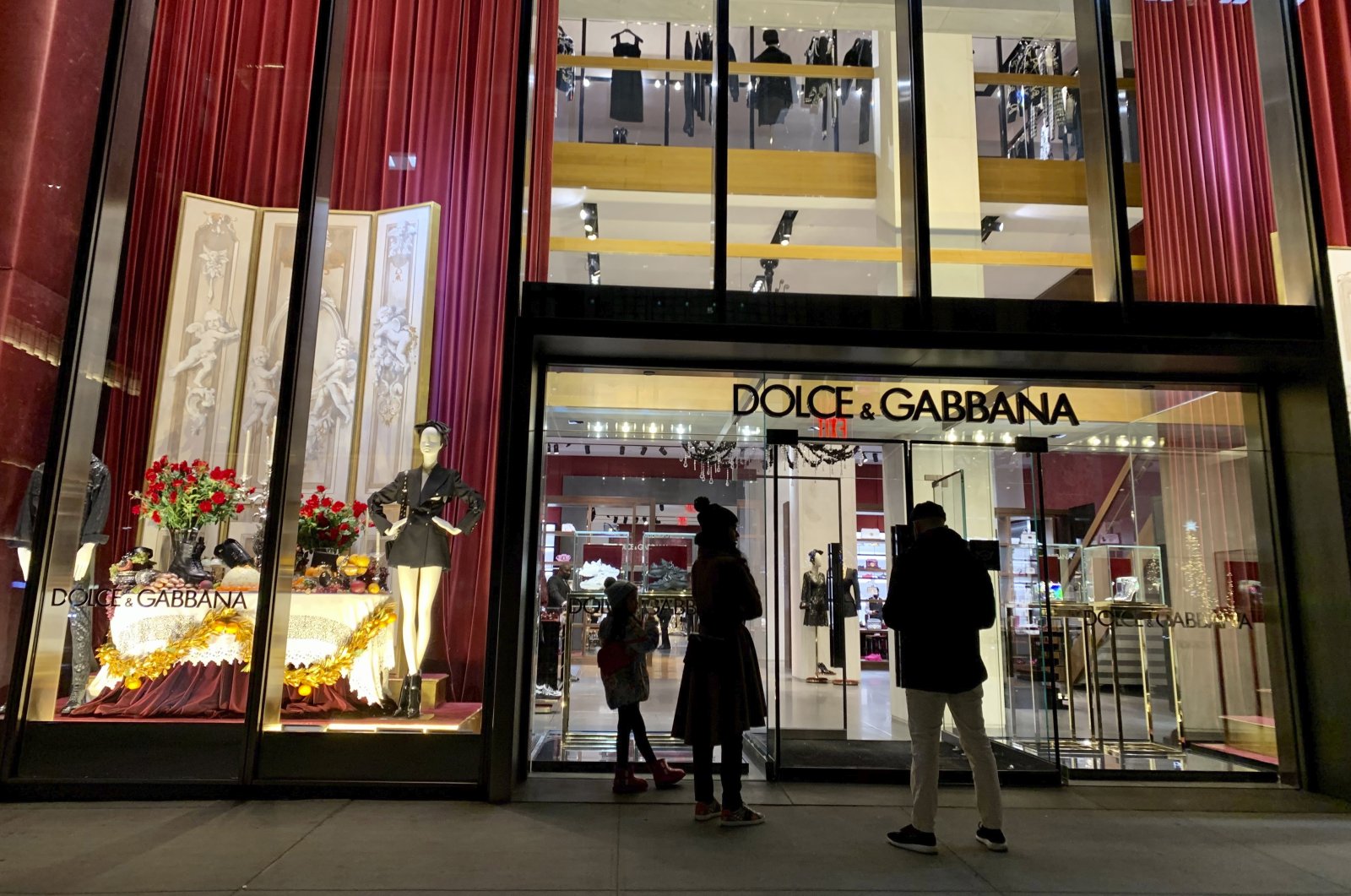 People stand outside the Dolce &amp; Gabbana store on Fifth Avenue, in New York City, U.S., Nov. 21, 2021. (AP Photo)