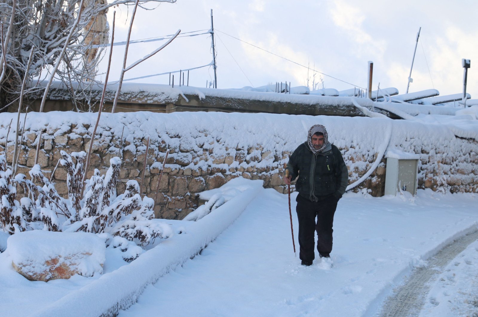 A man walks through a snow-covered road in Lebanon&#039;s historic city of Baalbek in the eastern Bekaa Valley, Jan. 27, 2022. (AFP Photo)