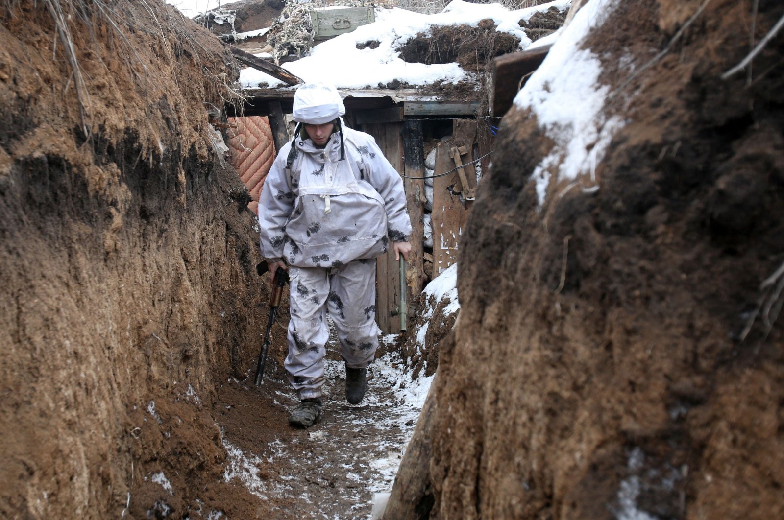 A Ukrainian serviceman walks along a snow-covered trench on the frontline with the Russia-backed separatists near Verkhnetoretskoye village, in the Donetsk region, Feb. 1, 2022. (AFP Photo)