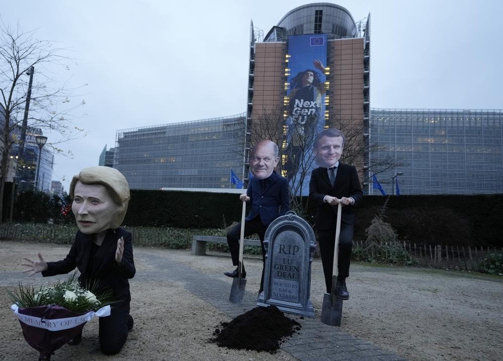 Climate activists pose wearing the masks of European Commission President Ursula von der Leyen (L), German Chancellor Olaf Scholz (C) and French President Emmanuel Macron during a demonstration in front of the EU headquarters in Brussels, Belgium, Feb. 2, 2022. (AP Photo)