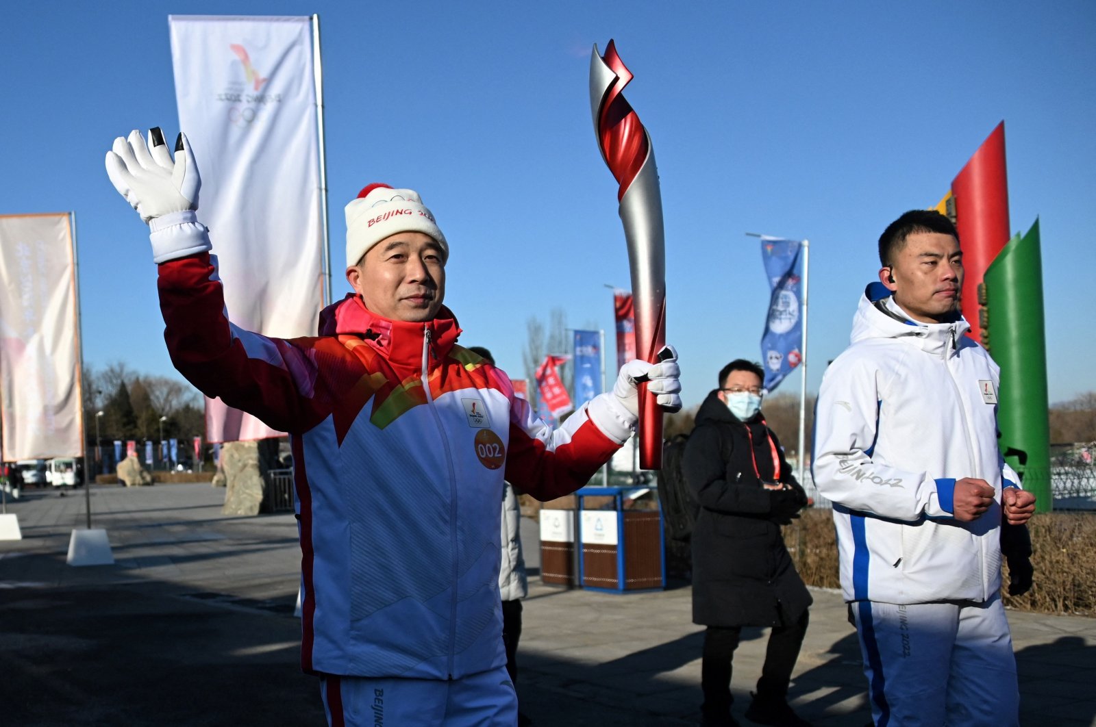 Chinese astronaut Jing Haipeng (L) holds the Olympic Torch during the torch relay launch ceremony at Olympic Forest Park, Beijing, China, Feb. 2, 2022. (AFP Photo)