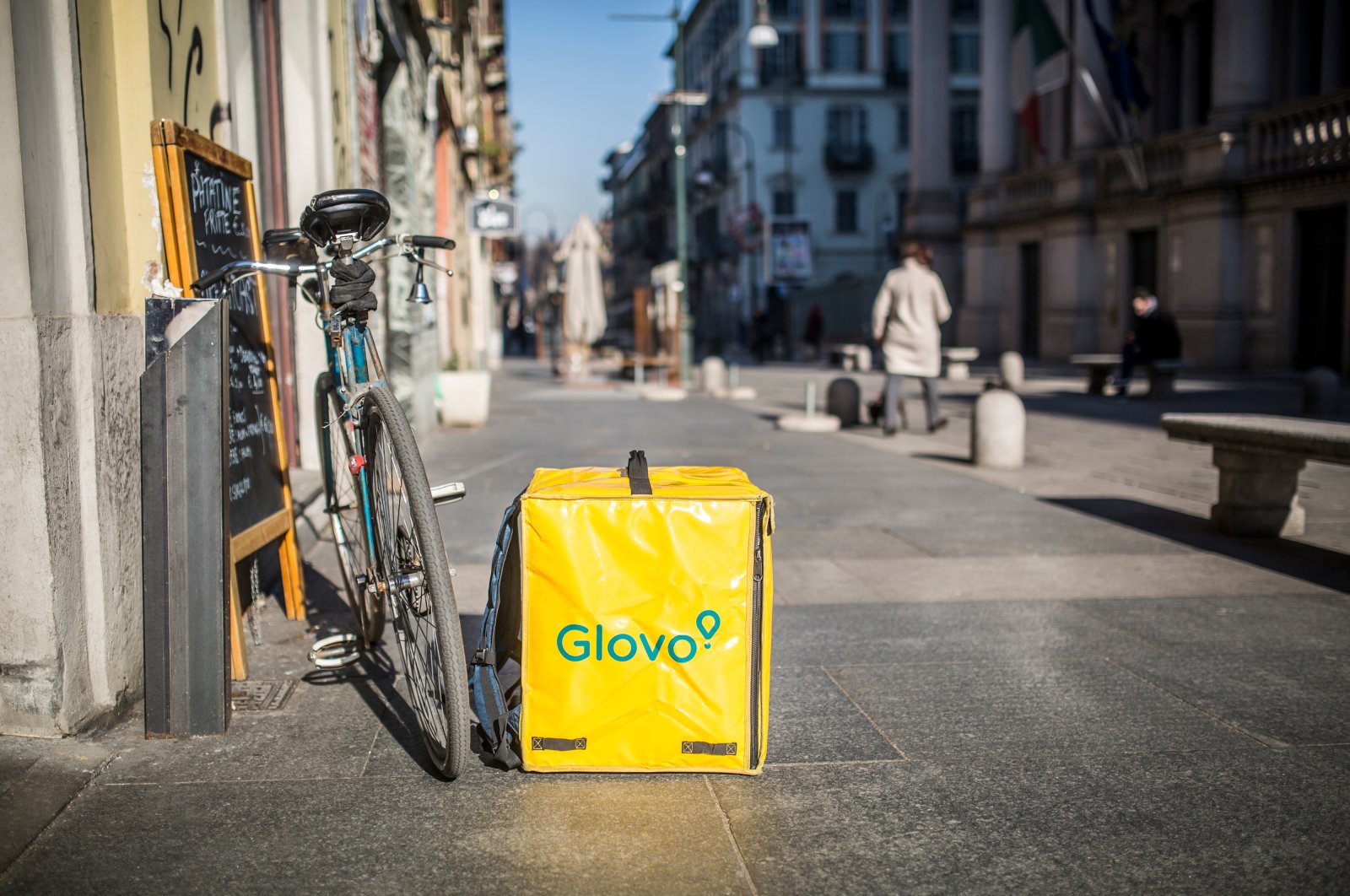 A Glovo delivery backpack is kept next to a delivery bike on the street of Turin, Italy, Feb. 5, 2019. (Shutterstock Photo)