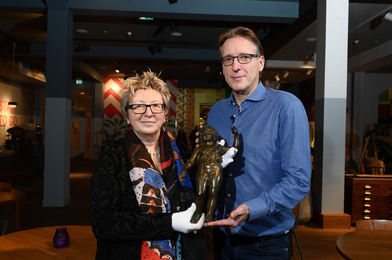 Dutch art detective Arthur Brand (R) hands over the retrieved Roman statue of Dionysus to Catherine Monnet (L), director of the French museum of Pays Chatillonais, in Amsterdam, The Netherlands, Jan. 31, 2022. (AFP Photo)