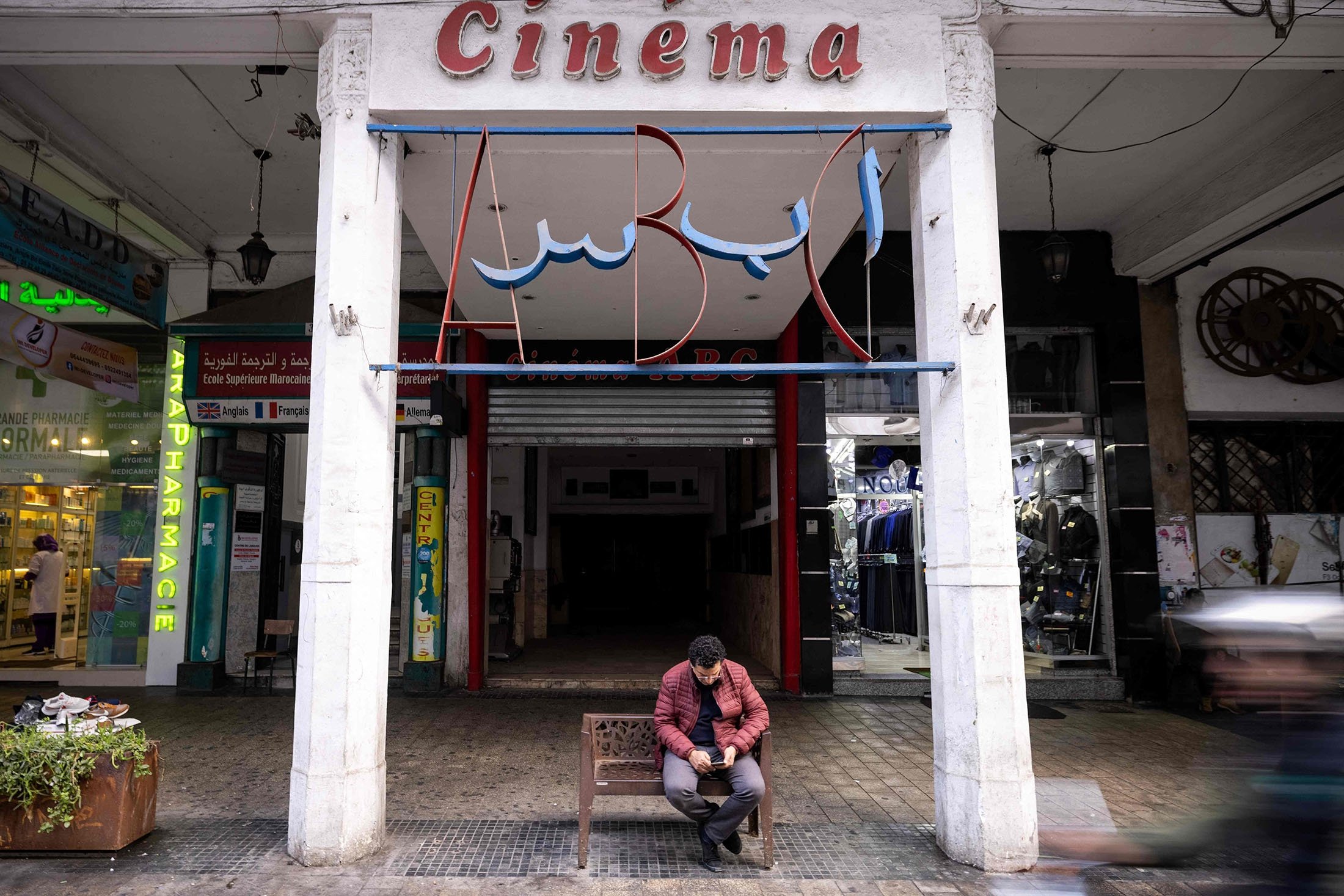 A man sits at the entrance of the ABC cinema, in the western city of Casablanca, Morocco, Jan. 24, 2022. (AFP Photo)