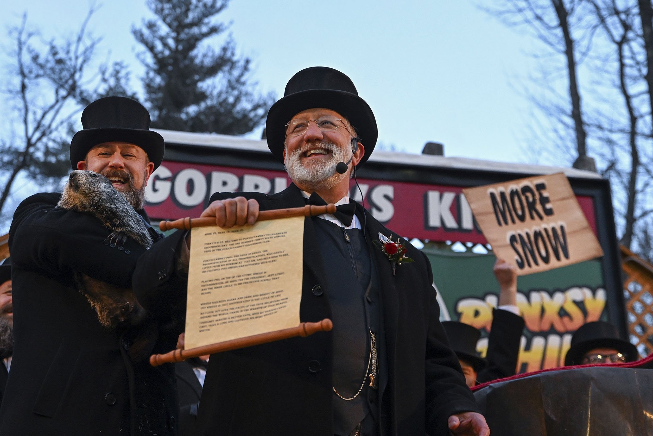 Groundhog Club handler A.J. Dereume (L) holds Punxsutawney Phil, as Vice President Tom Dunkel reads the scroll, during the 136th celebration of Groundhog Day on Gobbler's Knob in Punxsutawney, Pennsylvania, U.S., Feb. 2, 2022. (AP Photo)