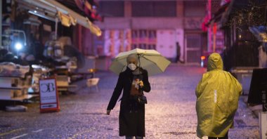 A woman wearing a protective mask against COVID-19 walks on a street, in Istanbul, Turkey, Feb. 3, 2022. (AA Photo)