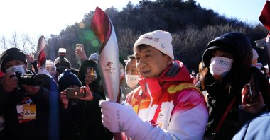 Hong Kong celebrity Jackie Chan holds the 2022 Winter Olympic torch during the torch relay at the Badaling Great Wall on the outskirts of Beijing, China, Feb. 3, 2022. (AP Photo)