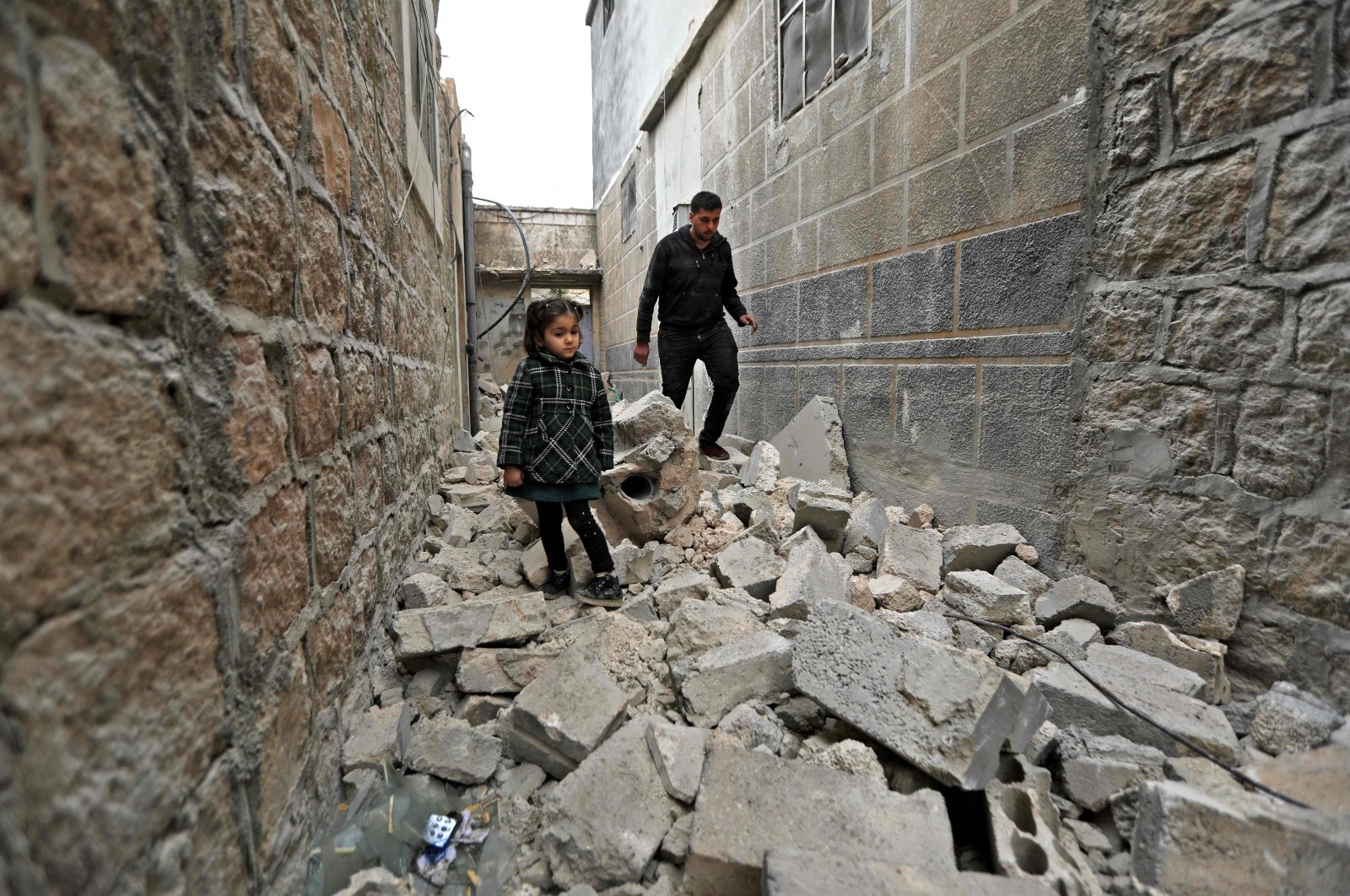 A man and a young girl walk on rubble following YPG/PKK&#039;s artillery shelling, in the Turkish-controlled city of al-Bab in northern Aleppo province on the border with Turkey, Syria, Feb. 2, 2022. (AFP Photo)