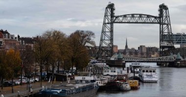 Barges docked on the Koningshaven waterway as the Koningshavenbrug "De Hef" lift bridge (R, rear) and the Koninginnebrug drawbridge (R, front) are seen in the background in Rotterdam, western Netherlands, Nov. 23, 2021.  (AFP Photo)