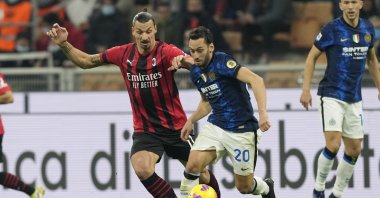 Milan's Zlatan Ibrahimovic (L) and Inter's Hakan Çalhanoğlu vie for the ball during a Serie A match at the San Siro, Milan, Italy, Sunday, Nov. 7, 2021. (AP Photo)