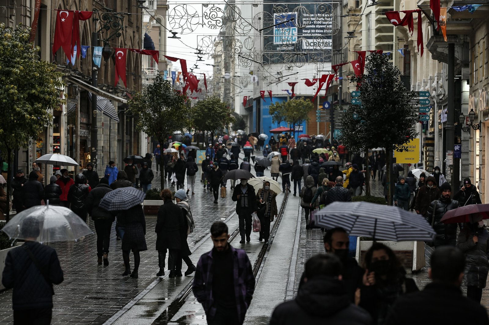 People walk in the rain on Istiklal Avenue, in Istanbul, Turkey, Feb. 3, 2022. (AP Photo)