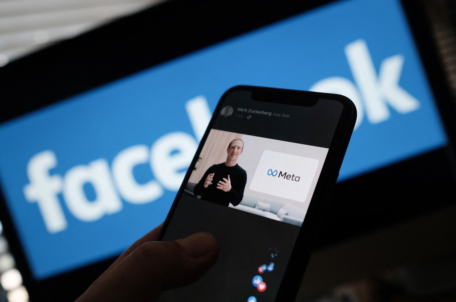 An illustration photo shows a person watching Facebook parent company Meta CEO Mark Zuckerberg unveiling the Meta logo from a smart phone in Los Angeles, U.S., Oct. 28, 2021. (AFP Photo)