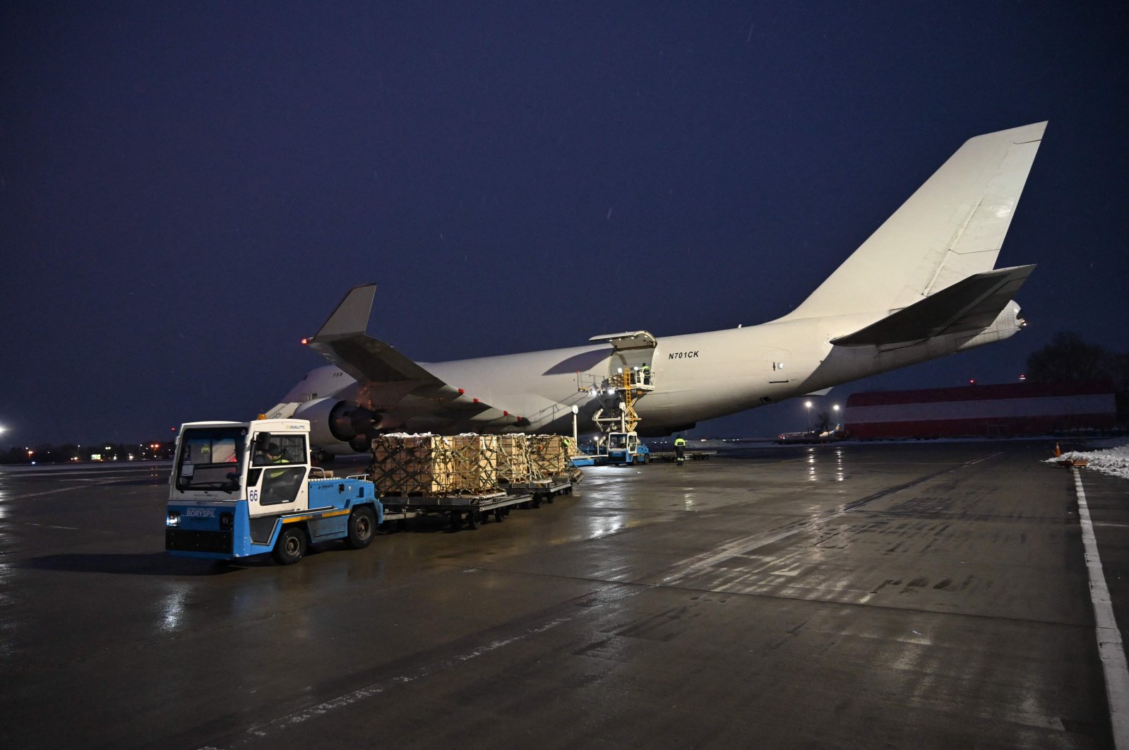 Employees unload a plane carrying U.S. military aid at Boryspil airport in Kyiv, Ukraine, Feb. 5, 2022. (Photo by GENYA SAVILOV / AFP)