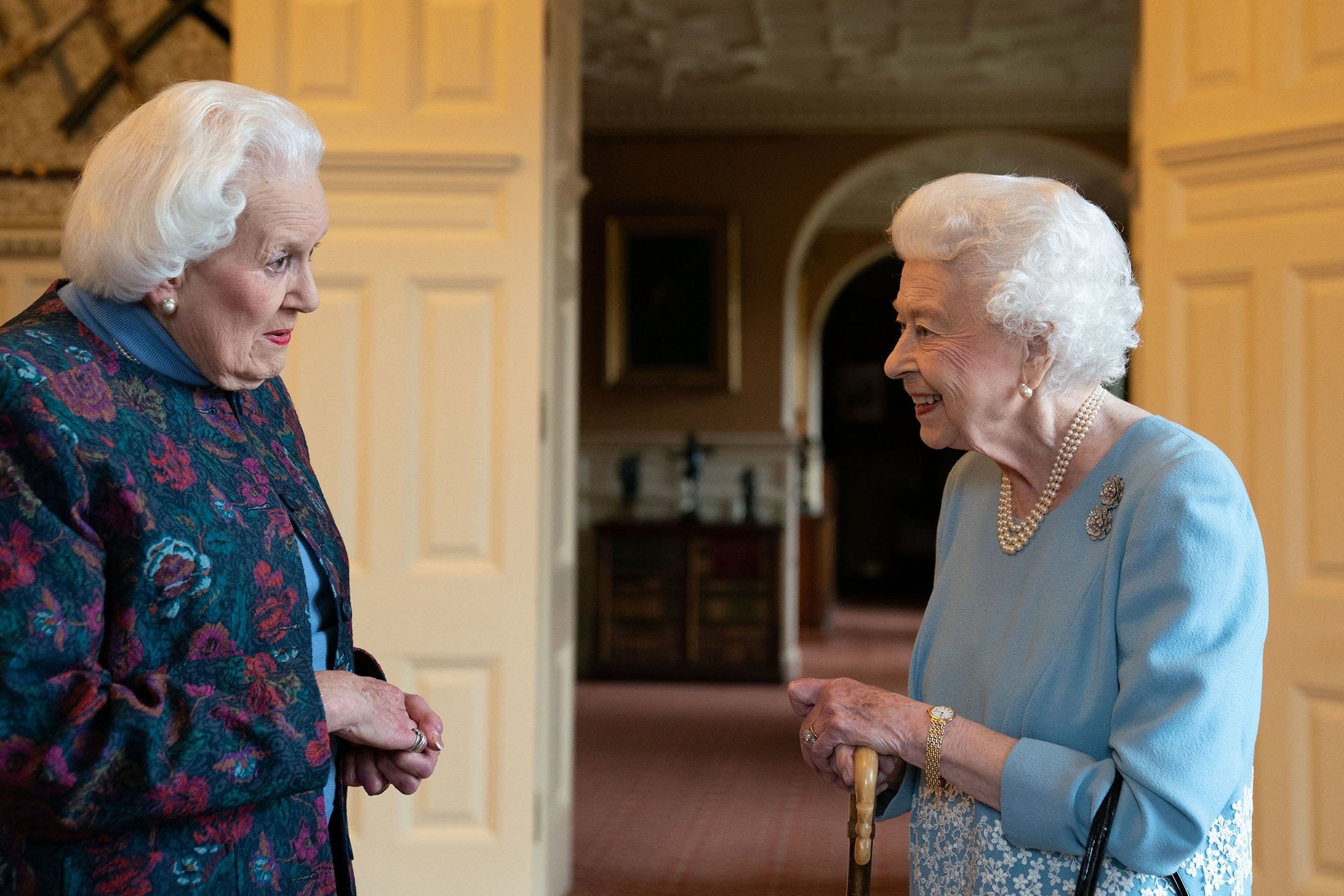 Britain's Queen Elizabeth II (R) meets Angela Wood (L), the woman who helped create coronation chicken, at a reception in the Ballroom of Sandringham House, the Queen's residence in Norfolk, U.K., Feb. 5, 2022. (AFP Photo)