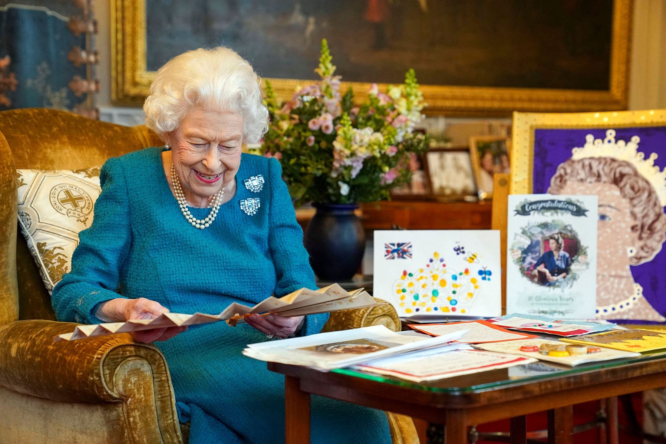 Queen Elizabeth II looks at Queen Victoria's Autograph fan, alongside a display of memorabilia from her Golden and Platinum Jubilees, in the Oak Room at Windsor Castle, west of London, U.K., Jan., 2022. (AFP Photo)
