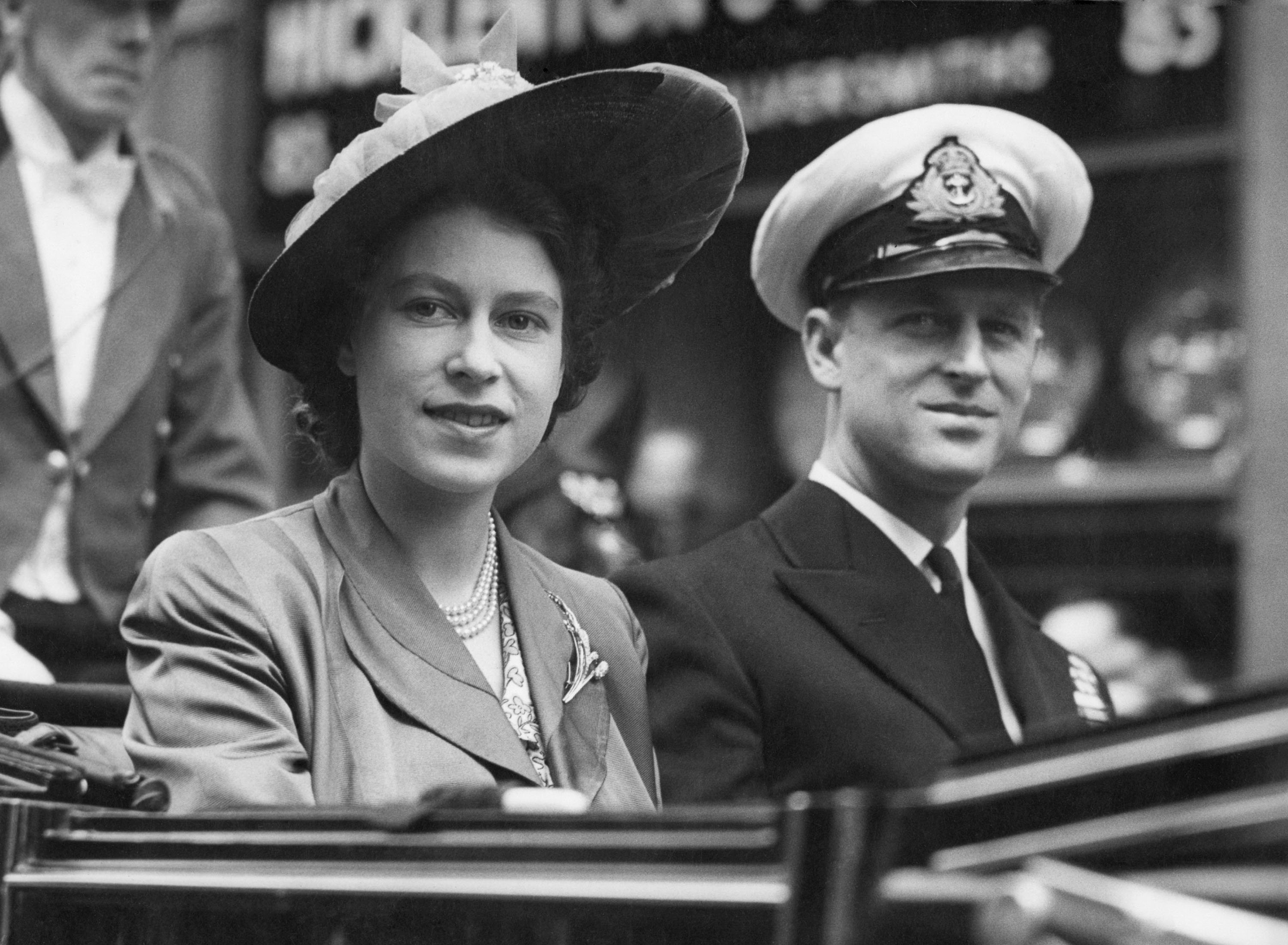 Princess Elizabeth (L) smiles as she rides with Prince Philip, in an open Landau, as they drive from the Guildhall, in London, U.K., June 8, 1948. (AP Photo)