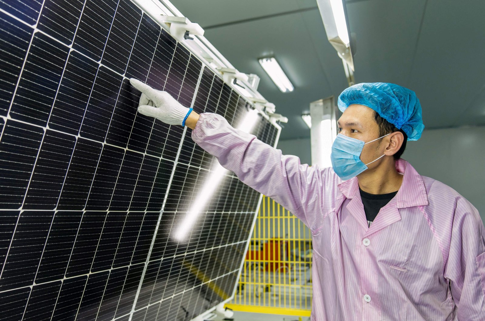 A worker checks solar photovoltaic modules used for small solar panels at a factory in Haian, China, Jan. 7, 2022. (AFP Photo)
