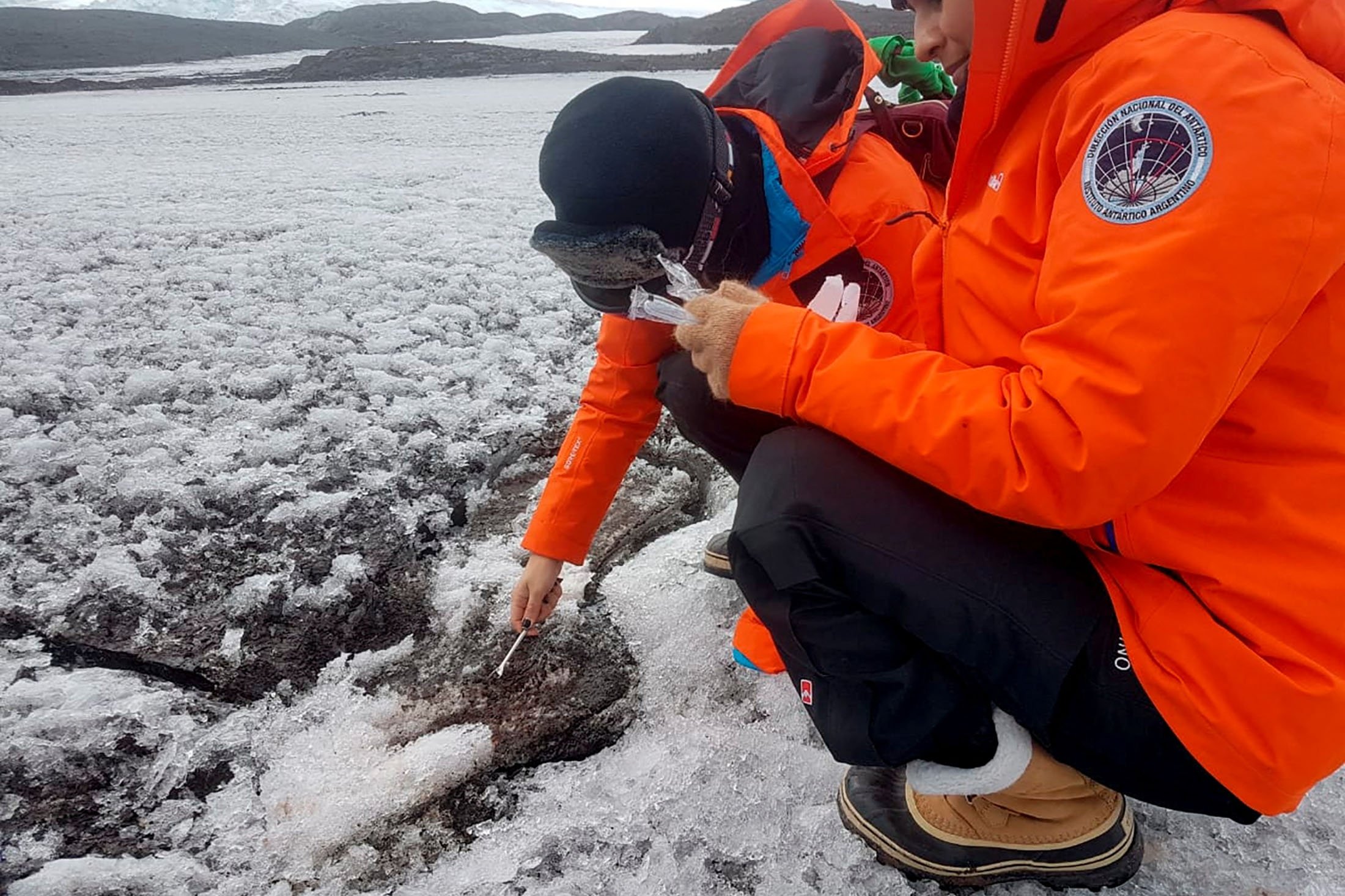 Dokter Argentina Mariela Torres dan dokter magang Nathalie Bernard mengambil sampel tanah Antartika, di Antartika, 30 Januari 2022. (Foto Reuters)