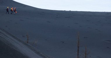 Members of the INVOLCAN technical team walk through the ash of the Cumbre Vieja volcano as they head to the crater, in Cabeza de Vaca, on the Canary Island of La Palma, Spain, Jan. 21, 2022. (Reuters Photo)