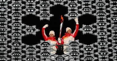 Chinese torchbearer athletes Dinigeer Yilamujian (L) and Zhao Jiawen wave with the Olympic flame during the Beijing Winter Games opening ceremony, Beijing, China, Feb. 4, 2022. (AFP Photo)