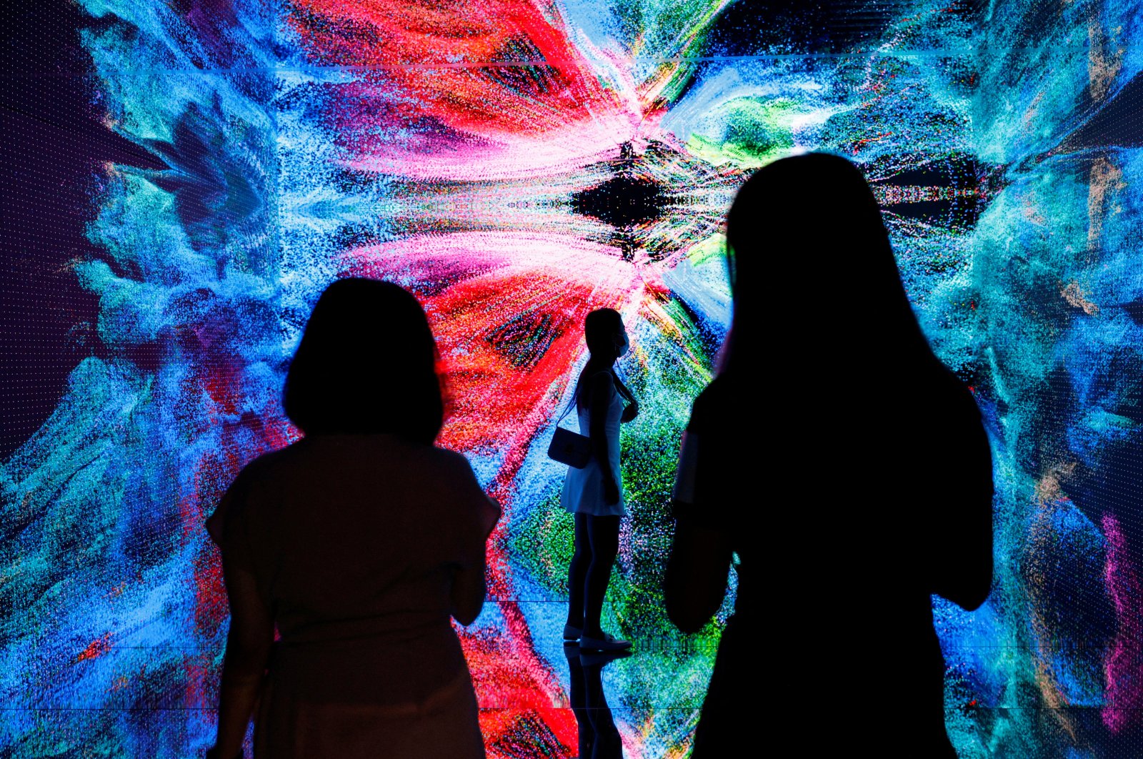 Visitors are pictured in front of an immersive art installation titled &quot;Machine Hallucinations – Space: Metaverse&quot; by Turkish media artist Refik Anadol, which will be converted into NFT and auctioned online at Sotheby&#039;s, at the Digital Art Fair, in Hong Kong, Sept. 30, 2021. (Reuters Photo)