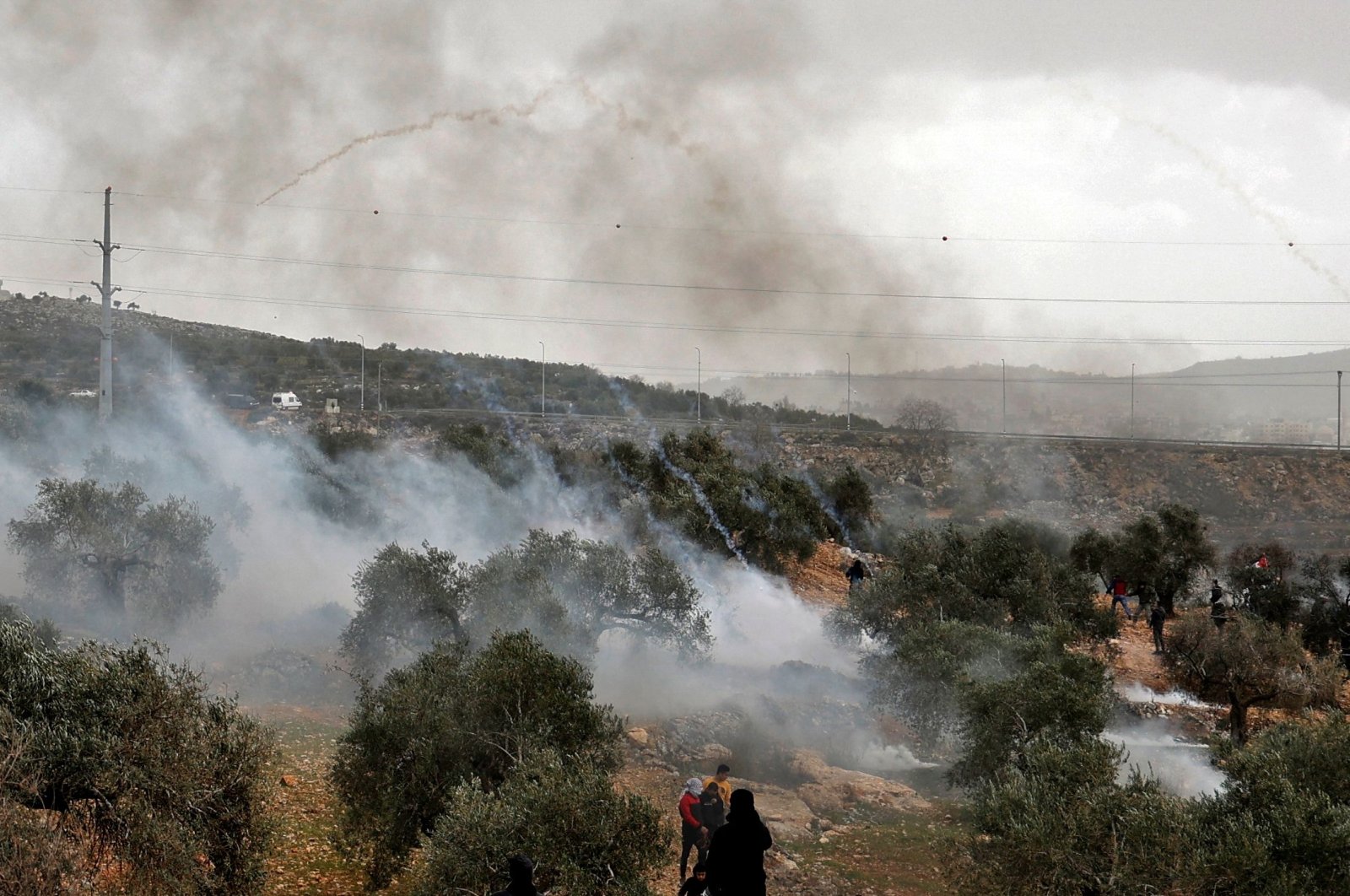Palestinian protesters retreat as tear gas canisters fall amid clashes with Israeli security forces following a demonstration against settlements in the village of Beita in the occupied West Bank, Palestine, Feb. 4, 2022. (AFP Photo)