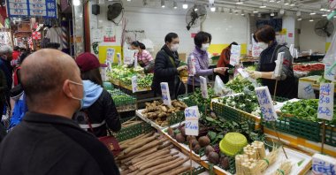 Customers wearing face masks shop for vegetables at a wet market in Tsuen Wan, Hong Kong, China, Feb. 8, 2022. (Reuters Photo)