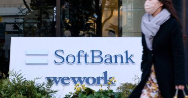 A pedestrian walks past signage outside the building where the SoftBank Group headquarters is located in Tokyo, Japan, Feb. 8, 2022. (AFP Photo)