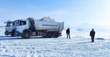 This file image provided on Feb. 7 shows municipality crews from the Karapınar district in the central province of Konya dumping snow near a lake. (DHA Photo)