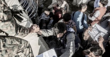 A U.S. Marine assists at an Evacuation Control Check Point (ECC) during an evacuation at Kabul Hamid Karzai International Airport, Kabul, Afghanistan, Aug. 26, 2021. (Reuters Photo)