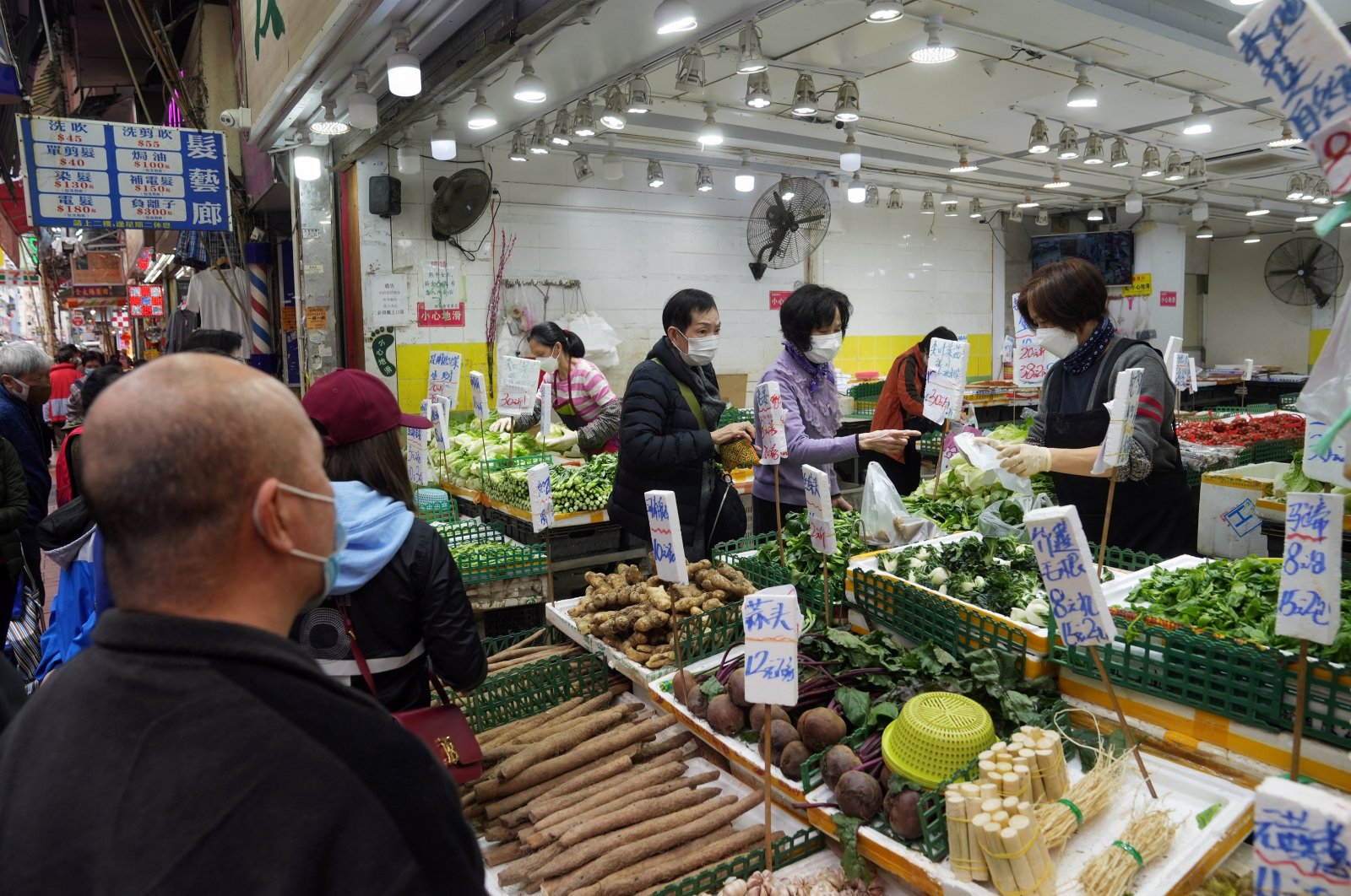 Customers wearing face masks shop for vegetables at a wet market in Tsuen Wan, Hong Kong, China, Feb. 8, 2022. (Reuters Photo)