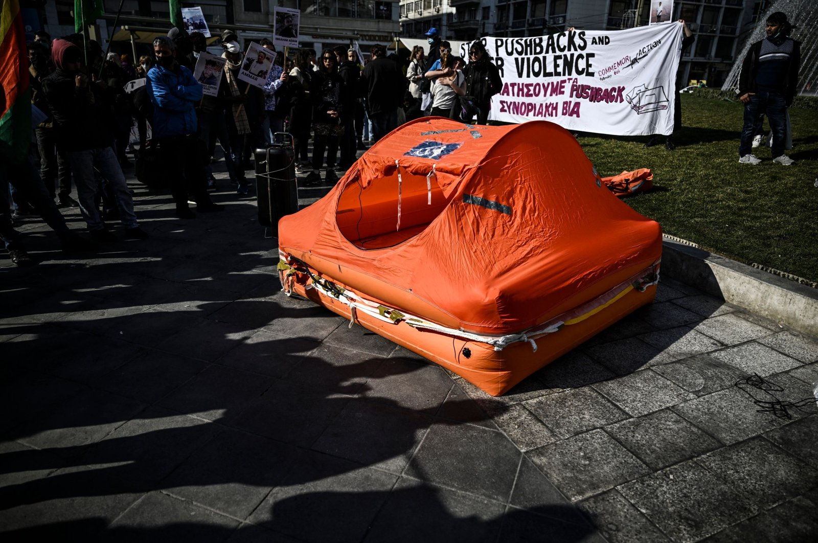 Protesters stand around a life raft during a demonstration against migrant pushbacks and border violence in central Athens, Greece, Feb. 6, 2022. (AFP Photo)