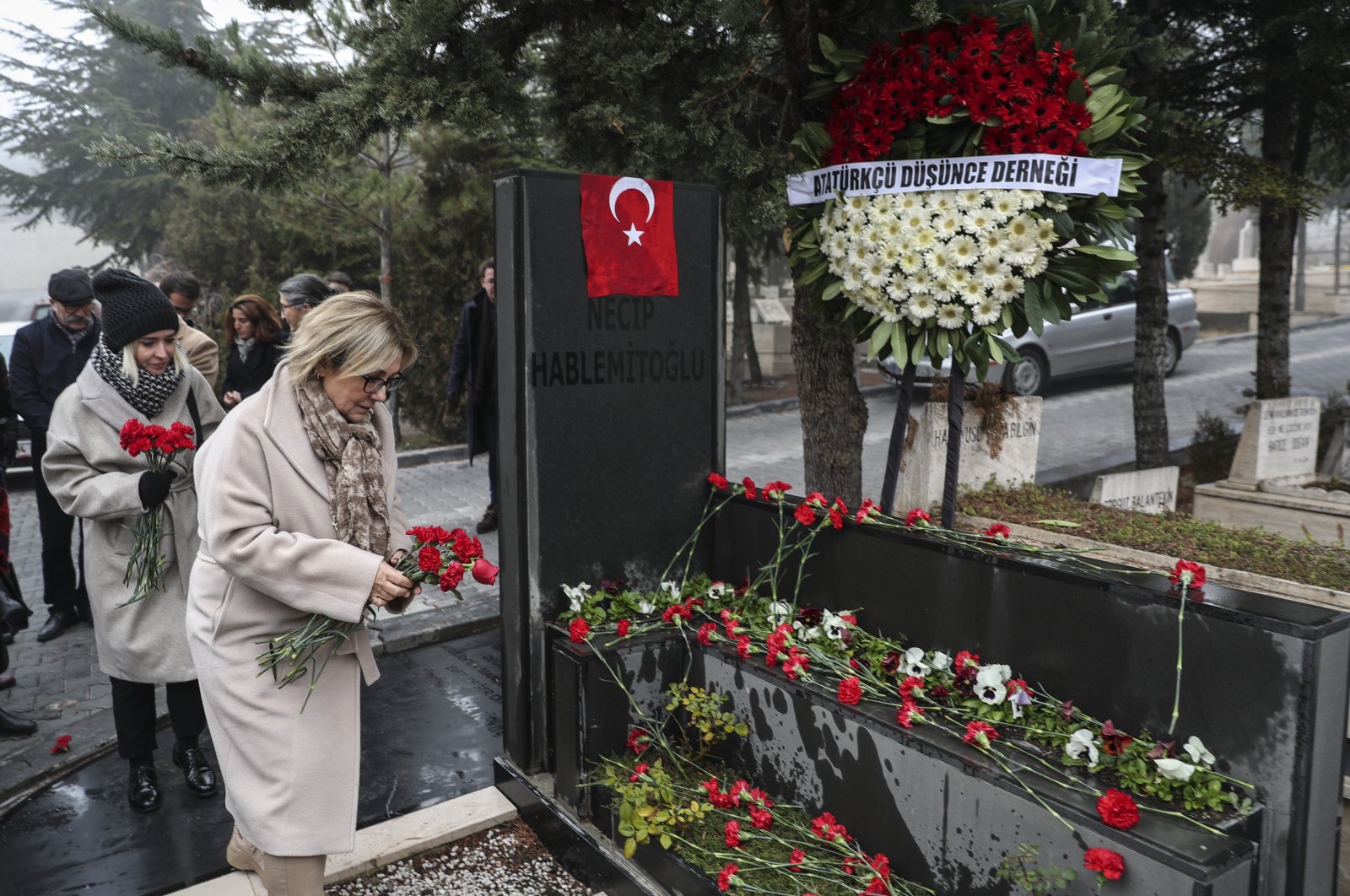 Şengül Hablemitoğlu leaves flowers on her husband Necip Hablemitoğlu&#039;s grave in the capital Ankara, Turkey, Dec. 18, 2019. (AA Photo)