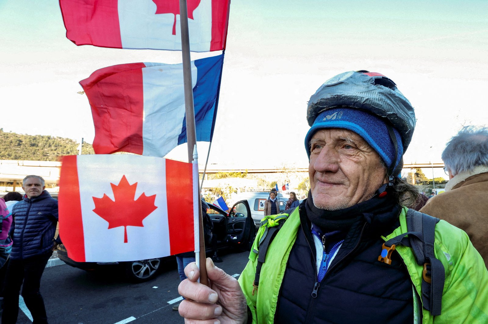 A French activist holds a Canadian flag before the start of their &quot;Convoi de la liberte&quot; (The Freedom Convoy), a vehicular convoy protest converging on Paris to protest COVID-19 restrictions in Nice, France, Feb. 9, 2022. (Reuters Photo)