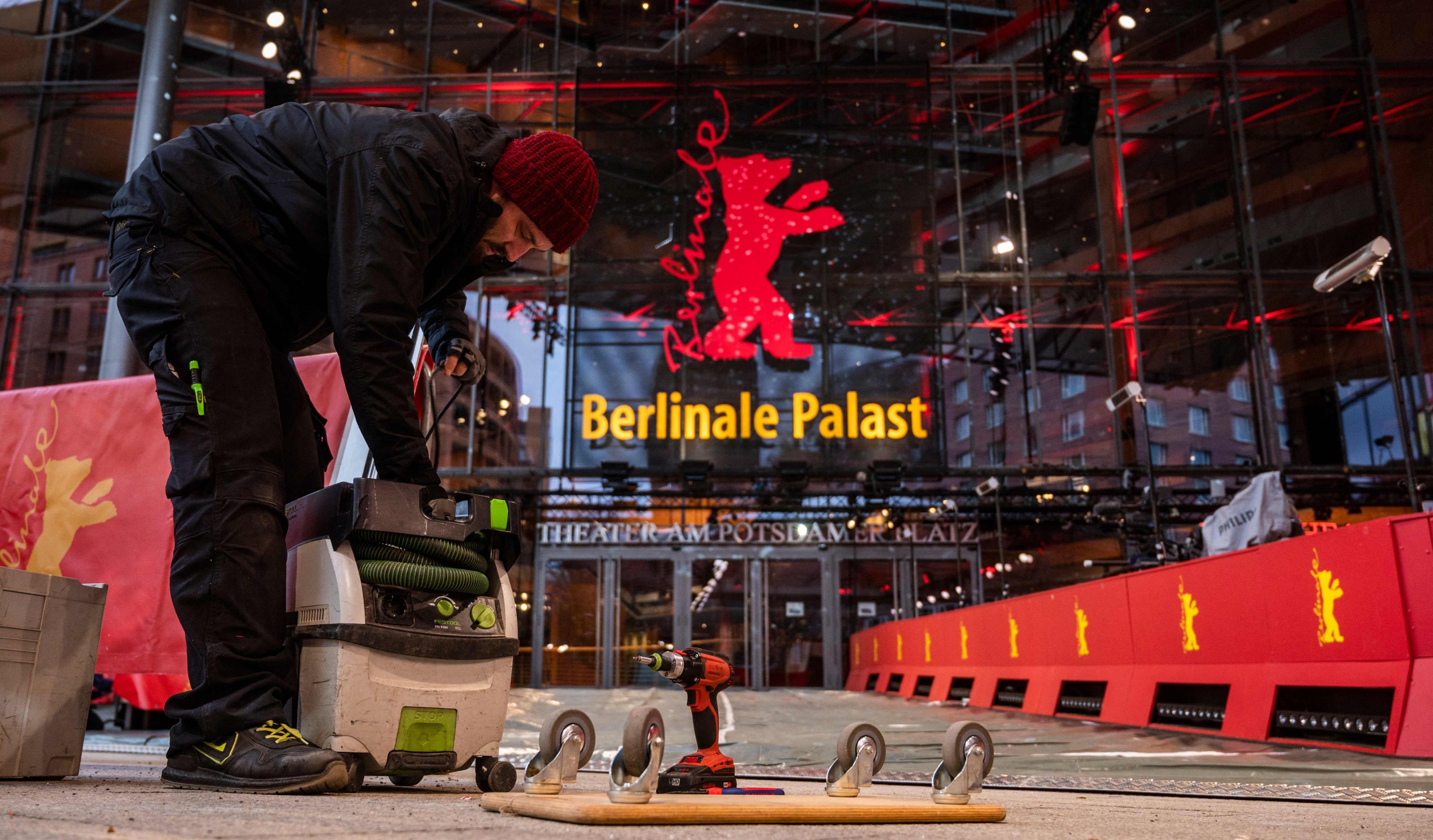 A worker bustles outside the Berlinale palace in Berlin on February 9, 2022 as last minute work is carried out ahead of the opening of the 72nd Berlinale <a class=