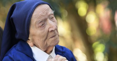 This file photo shows Sister Andre, Lucile Randon in the registry of birth and born on Feb. 11, 1904, the eldest French and European citizen, praying in a wheelchair, on the eve of her 117th birthday in an EHPAD (Housing Establishment for Dependant Elderly People) in Toulon, southern France, Feb. 10, 2021. (AFP Photo)