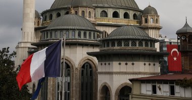 The French flag flies on the premises of France's consulate in Istanbul, with a mosque still under construction in the background, Istanbul, Turkey, Oct. 28, 2020. (AP File Photo)