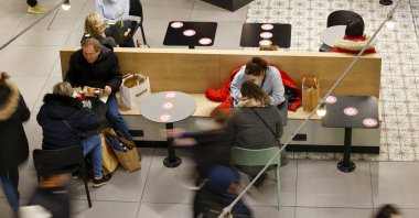 People have a snack in a shopping mall in Brussels, Belgium, Nov. 27, 2021. (AP Photo)