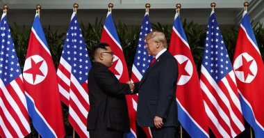 North Korean leader Kim Jong Un (L) and U.S. President Donald Trump shake hands prior to their meeting on Sentosa Island in Singapore on June 12, 2018. (AP File Photo)
